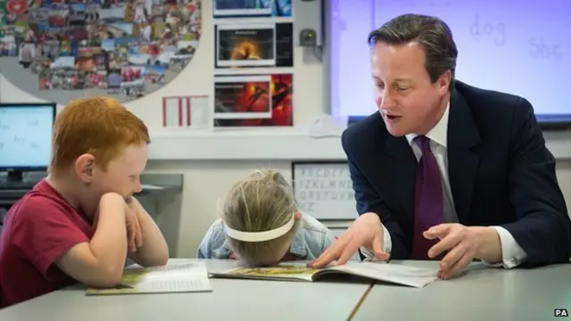 David Cameron helps with a reading lesson at the Sacred Heart Roman Catholic Primary School in Westhoughton near Bolton where he met pupils - 8 April 2015