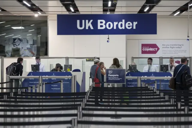 Border Force check the passports of passengers arriving at Gatwick Airport