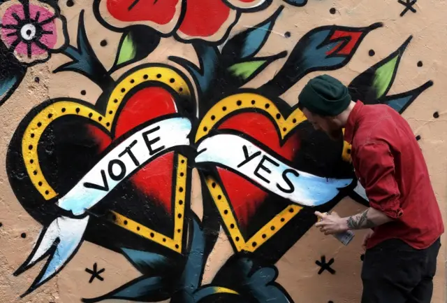 A graffiti artist finishes a Yes campaign piece in central Dublin in Ireland