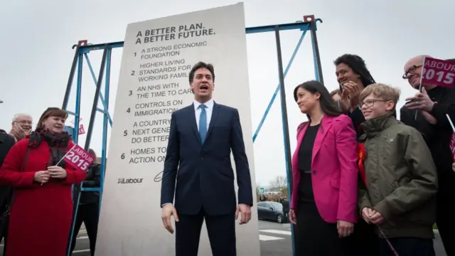 Ed Miliband stands in front of a stone plinth