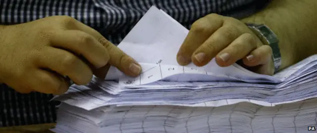 Close up of a person counting ballot papers