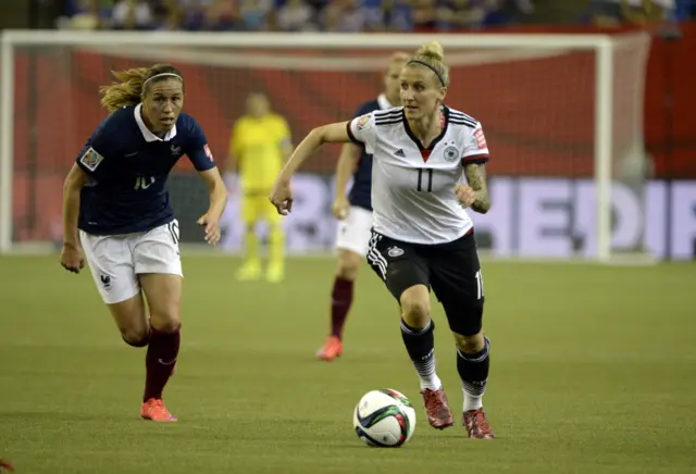 Anja Mittag controls the ball against France midfielder Camille Abily