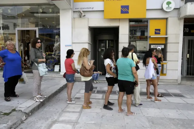 People line up outside a Piraeus bank branch in Athens