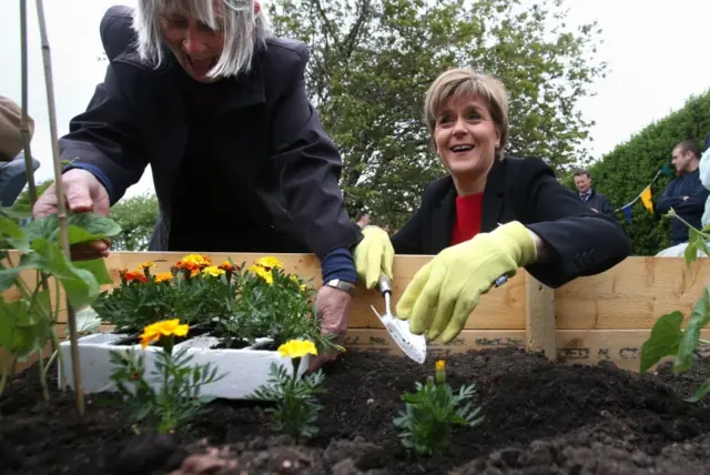 Nicola Sturgeon plants marigold plants with volunteer