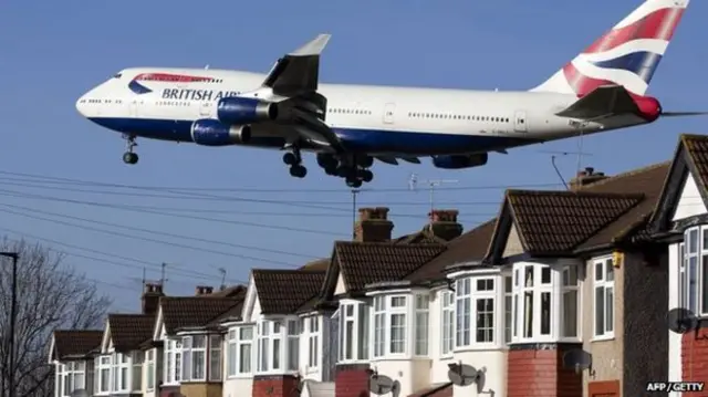 Plane passes over houses