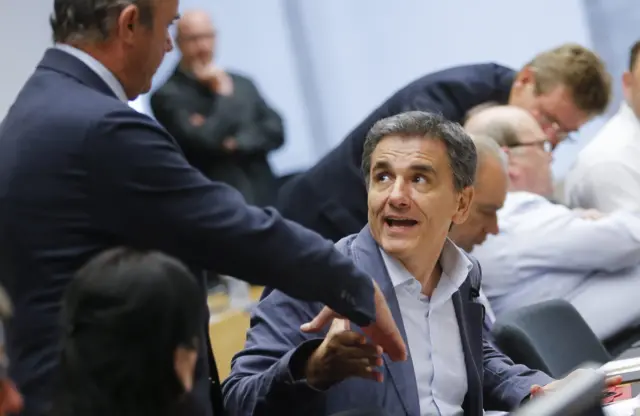 Greek Finance Minister Euclid Tsakalotos (right) and Spanish Economy Minister Luis de Guindos (left) shake hands