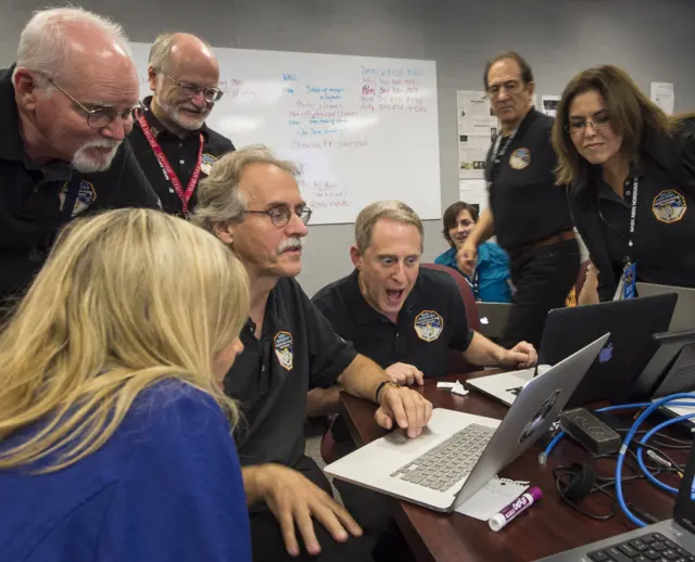 Mission scientists poring over images on a laptop