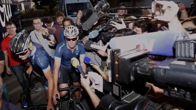 Lance Armstrong surrounded by journalists