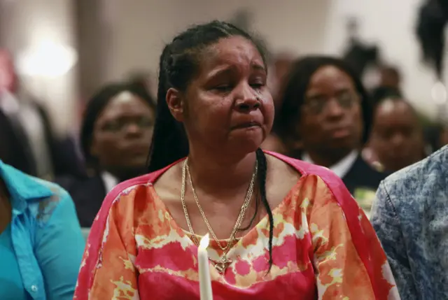 Esaw Garner (C), widow of Eric Garner, sheds a tear while holding a candle during the Interfaith Prayer Service for Healing and Reconciliation at the Mount Sinai United Christian Church in the Staten Island borough of New York July 14, 2015.