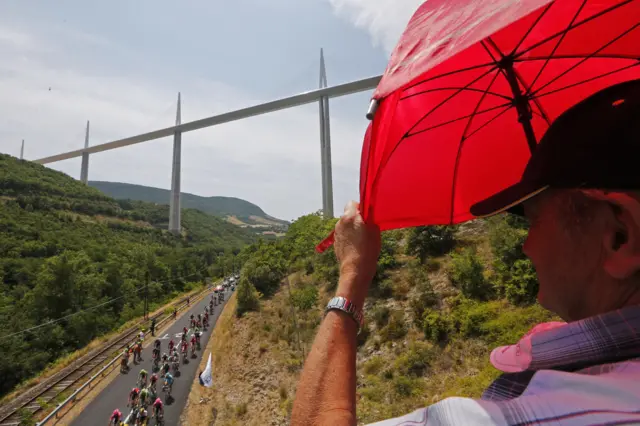 A spectator watches as the pack ride past