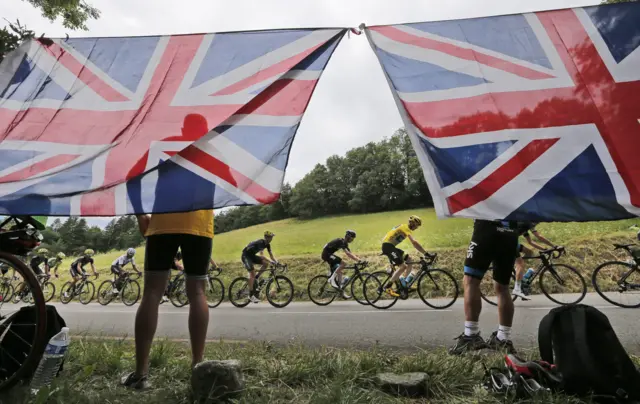 Chris Froome cycles past British flags