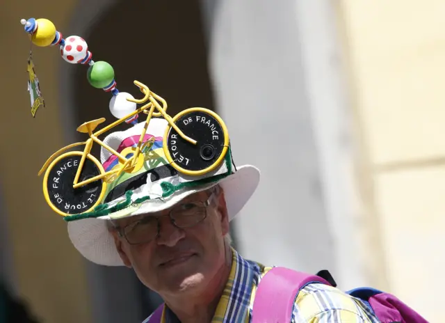 Fan wears hat with yellow bike during the 19th stage