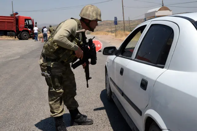 A Turkish soldier checks cars at a checkpoint in Diyarbakir on July 26, 2015 following the death of two Turkish soldiers