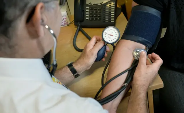 GP checking a patient's blood pressure