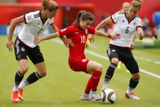 Karen Carney holds off two German defenders