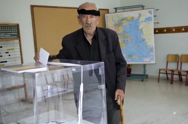 A man wearing a traditional headscarf casts his ballot at a polling station at the village of Anogeia in the island of Crete, Greece 5 July 2015