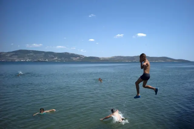 Youths swim at the beach of Elefsina, near Athens, Greece 5 July 2015.