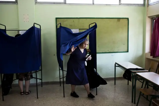 A woman leaves a voting booth at a polling station during a referendum on austerity measures in Athens on July 5, 2015.