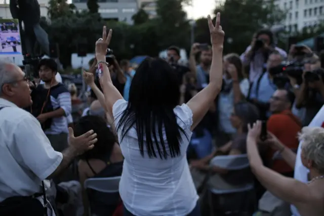 A supporter of the No vote makes the victory signs after the referendum"s exit polls at Syntagma square in Athens, 5 July 2015