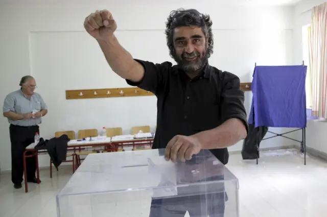 A man gestures as he casts his ballot at a polling station at the village of Anogeia in the island of Crete, Greece 5 July 2015.