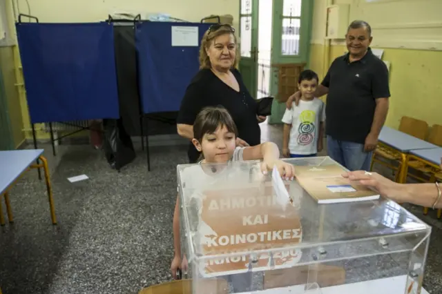 A child casting her grandmother's ballot in Athens, Greece