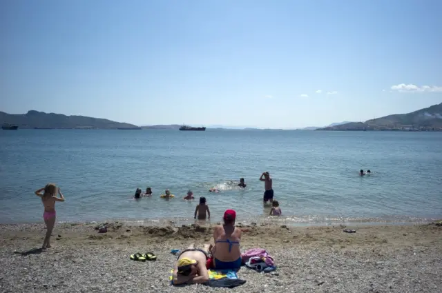 People relax at the beach of Elefsina, near Athens, Greece 5 July 2015