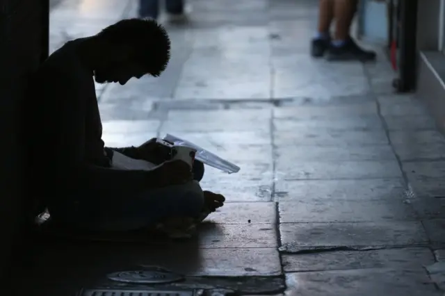 A man begs on the street near the Perama Shipyard on July 8, 2015 in Athens, Greece