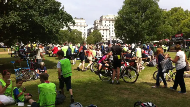 People on the grass, some on bikes, some sat next to bikes having picnics