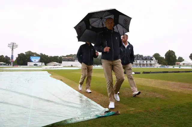 Umpires inspect the pitch