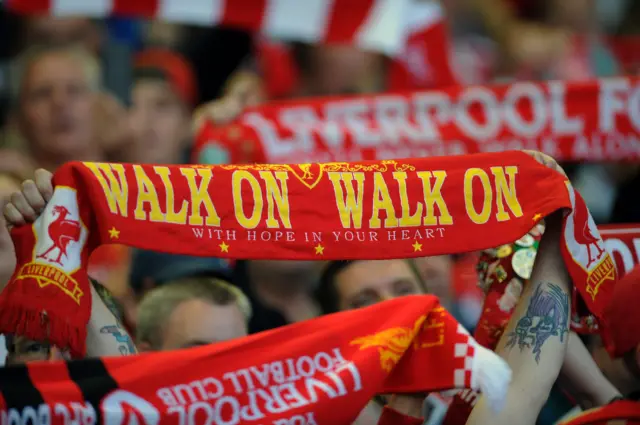 Liverpool fans hold up their scarves