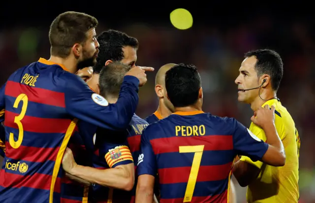 Gerard Pique surrounds the referee