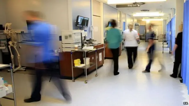 Hospital staff walking through ward