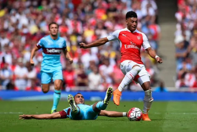 Alex Oxlade-Chamberlain leaps over a challenge from Dimitri Payet