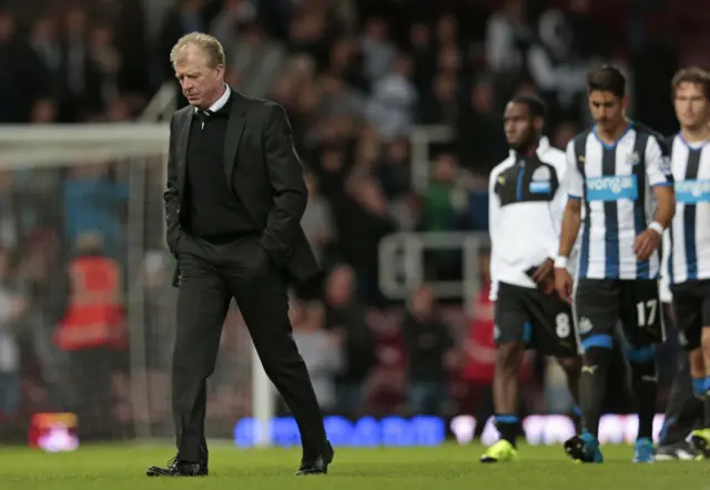 Steve McLaren walks from the pitch with players behind