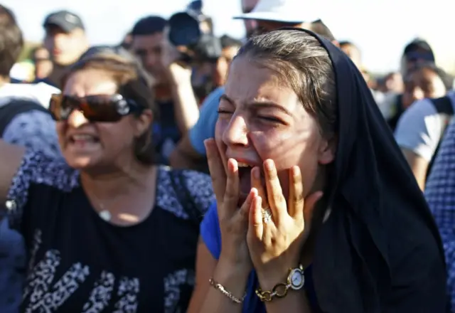 A woman cries as police blocks migrants from walking towards the Greece border on a highway near Edirne, Turkey