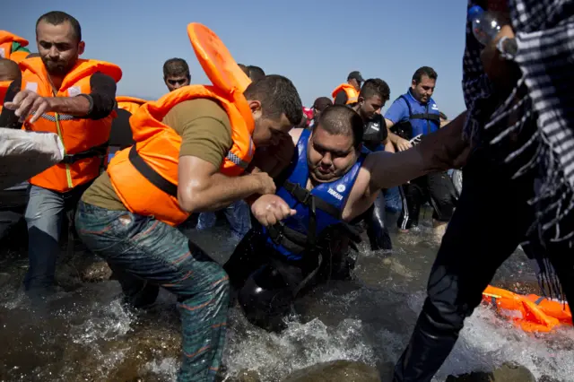 Migrants arrive aboard a dinghy after crossing from Turkey, to the island of Lesbos, Greece