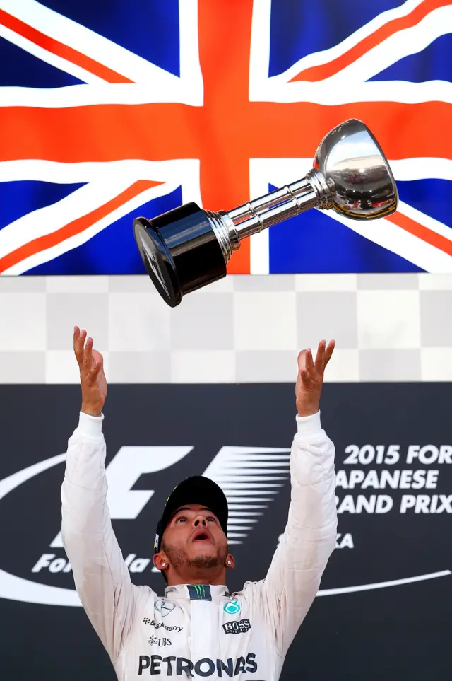 Lewis Hamilton throws trophy in the air