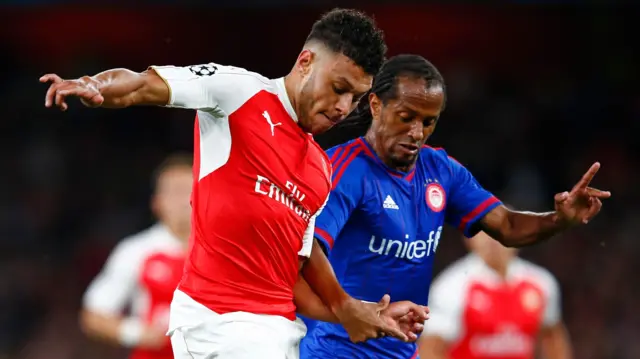 Alex Oxlade-Chamberlain of Arsenal is tackled by Leandro Salino of Olympiacos during the UEFA Champions League Group F match