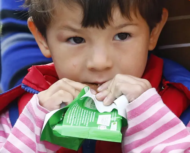 A child eating chocolate as migrants arrive at the main station in Munich, Germany