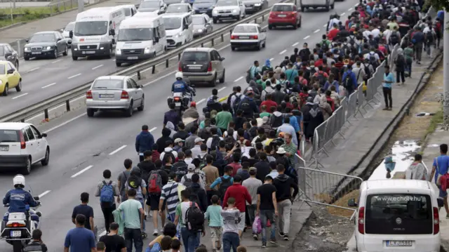 Migrants walk down a street from Keleti train station in Budapest, Hungary