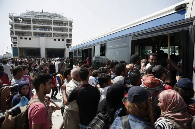 Migrants and refugees wait board a bus which will transport them to a metro station, after their arrival from the northeastern Greek island of Lesbos