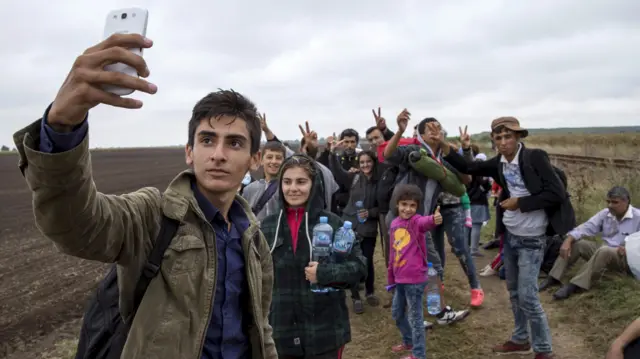 lvand, 18, from Kobane, Syria takes a selfie with his friends as they walk along a railway track after crossing into Hungary from the border with Serbia