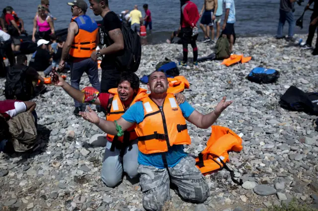 Refugees from Syria pray after arriving on the shores of the Greek island of Lesbos