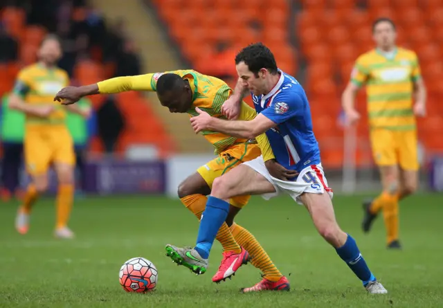 Francois Zoko and Luke Joyce vie for the ball