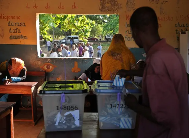 Tanzanians cast their ballots for the Tanzanian presidential elections as others queue at a polling station on October 25, 2015 in Zanzibar