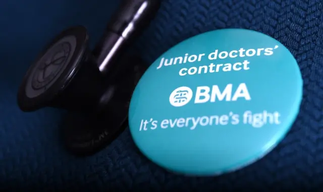 Doctor wearing a badge next to her stethoscope