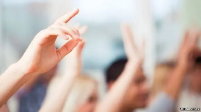 Children's hands up in classroom