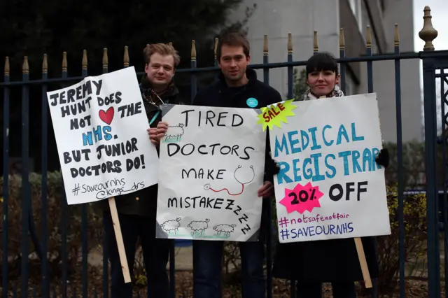 Junior doctors pose for a photograph with placards