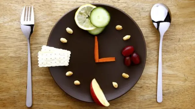 A clock made up of of food on a plate.