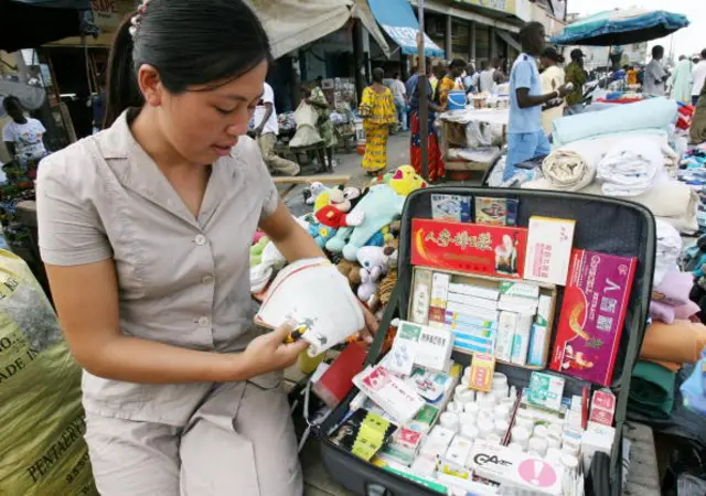 A woman sells Chinese medications at a market in Abidjan, 3 November 2006